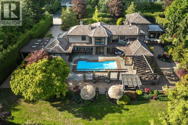 Overhead view of a sprawling luxury home featuring a blue swimming pool and an outdoor covered patio. - 2514 East Road, Anmore
