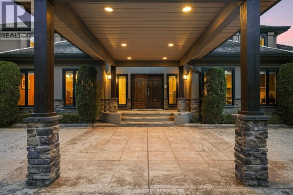 Close-up view of the stone-clad pillars supporting a covered entryway leading to double wooden front doors. - 2514 East Road, Anmore