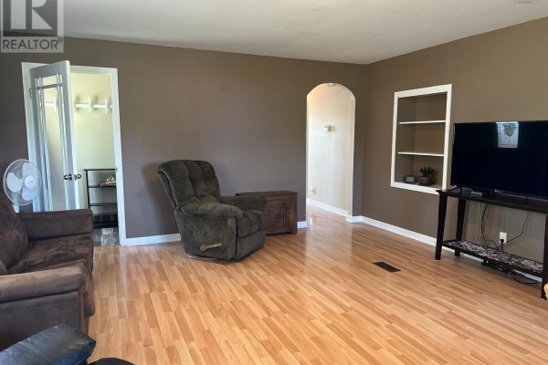 Living room featuring couches, a recliner, archway, shelving unit, and a television. - 2515 Highway 2, Shubenacadie