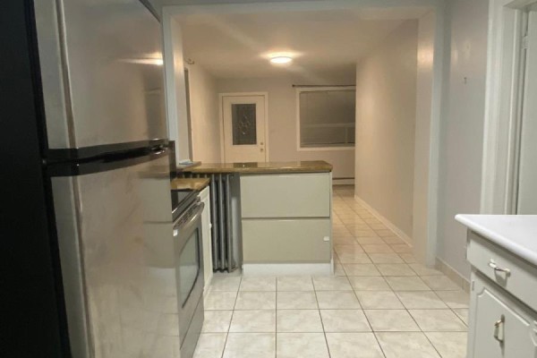 View from dining area into kitchen with stainless steel appliances and white cabinets. - 2518 Lake Shore Boulevard, Toronto