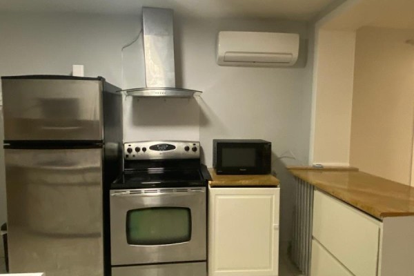 Stainless steel refrigerator, stove, microwave, and range hood in a modern kitchen. - 2518 Lake Shore Boulevard, Toronto