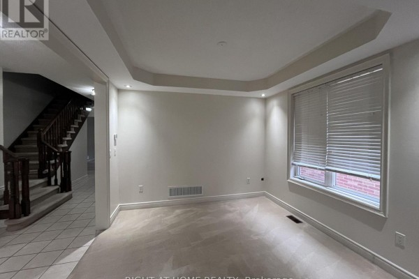 Living room with carpet, tray ceiling, recessed lighting, and a large window. - 2518 Rugby Road, Mississauga