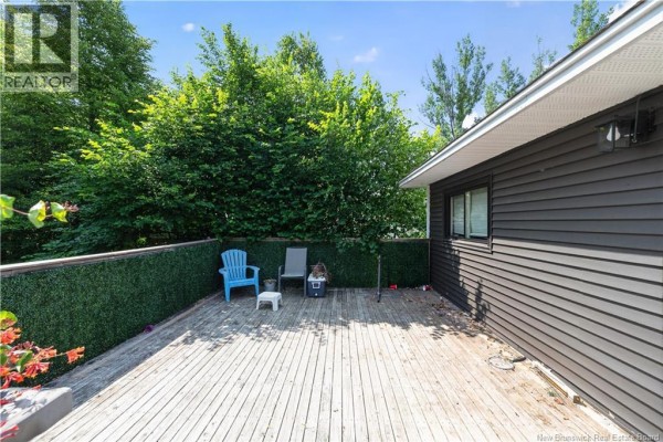 A wooden deck with two chairs and a green hedge backdrop. - 252 Buckingham Avenue, Riverview
