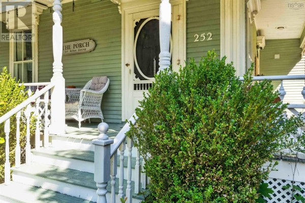 Front door of the house with number 252, a screen door, and a wicker chair on the porch. - 252 Main Street, Berwick