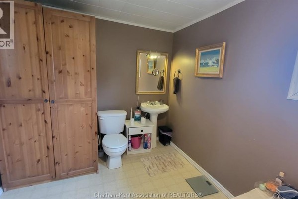 Bathroom with wood closet, pedestal sink, toilet, and mirror - 252 Queen Street Highgate