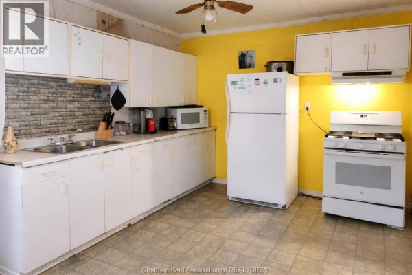 Kitchen with white cabinets, double sink, fridge, gas range - 252 Queen Street Highgate