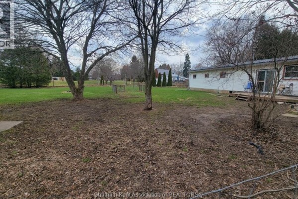 Backyard with trees, fence, deck, and sliding glass door - 252 Queen Street Highgate