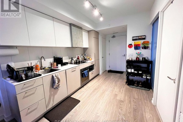 Kitchen with light wood floors, white cabinets, and stainless steel appliances. - 2520 - 19 Western Battery Road, Toronto