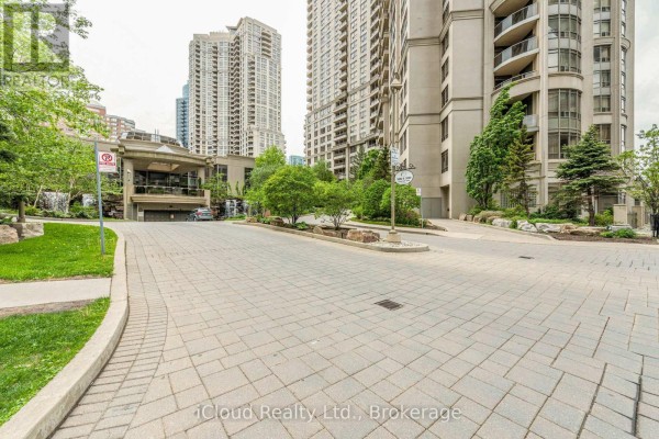 Paved driveway and walkway with grass, trees, and view of apartment buildings. - 2521 - 3888 Duke Of York Boulevard, Mississauga