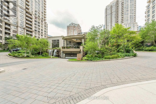 View of the apartment building entrance with waterfalls and paved circular driveway. - 2521 - 3888 Duke Of York Boulevard, Mississauga