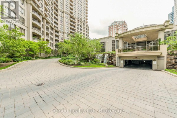 Paved driveway with landscaping, waterfalls, and the entrance to an apartment building. - 2521 - 3888 Duke Of York Boulevard, Mississauga