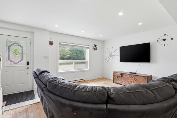 Living room with a sectional sofa, television, and a large window overlooking the yard. - 2523 Rue St-louis, Gatineau