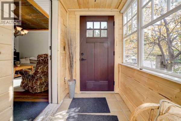 Entryway with wooden paneled walls, a glass-paned door, and tile flooring. - 2526 211 Street, Bellevue