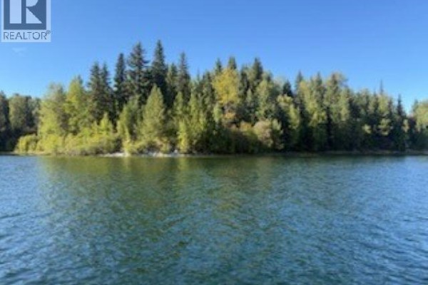 The water is calm and blue, with ripples spreading outwards from the foreground. - 25260 N Ness Lake Road, Prince George