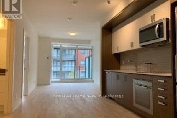 View of the open living space and compact kitchen with stainless steel appliances. - 253 - 1575 Lakeshore Road W, Mississauga