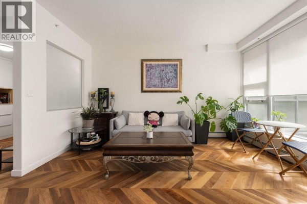 Hallway with herringbone wood floor, white walls, and doorway to bathroom. - 253 108 W 1st Avenue, Vancouver
