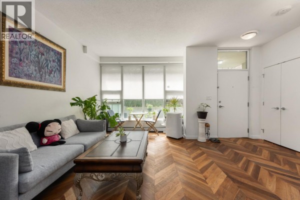 Balcony with glass railing overlooking a courtyard with trees and buildings. - 253 108 W 1st Avenue, Vancouver