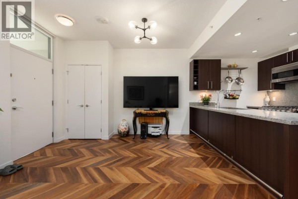 Bathroom with bathtub, toilet, vanity with dark wood cabinets, and tiled walls. - 253 108 W 1st Avenue, Vancouver