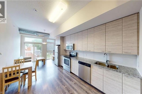 Close-up of the kitchen featuring granite countertops and ample storage space. - 253 Albert Street Unit# 216, Waterloo