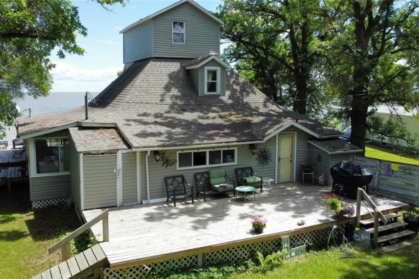 Side view of grey house with large wooden deck and patio furniture. - 253 Gimli Road, Whytewold