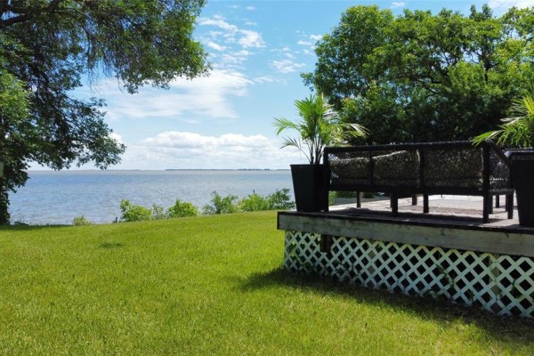 View of the lake and sky from a wooden deck with outdoor seating. - 253 Gimli Road, Whytewold