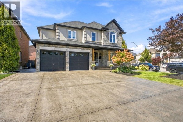 Side exterior view of a large stone and stucco house with a three-car garage. - 253 Upper Mount Albion Road, Stoney Creek