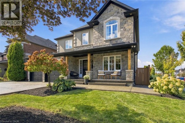 Front porch of a stone house with seating, leading to a dark front door. - 253 Upper Mount Albion Road, Stoney Creek