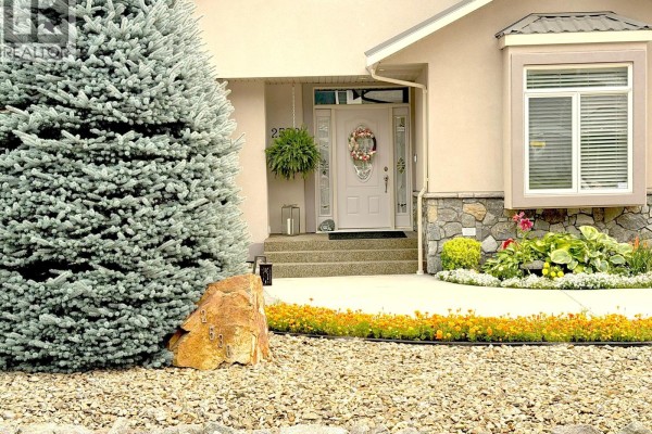 Close-up of the home's entrance with a white door, wreath, and decorative stone accents. - 2530 Valley Place, Blind Bay