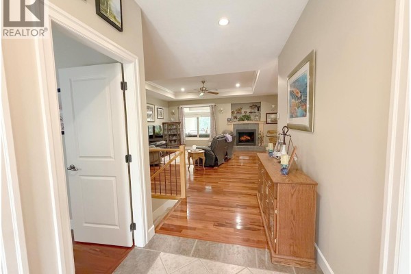 View from the entryway looking into a living room with hardwood floors and a fireplace. - 2530 Valley Place, Blind Bay