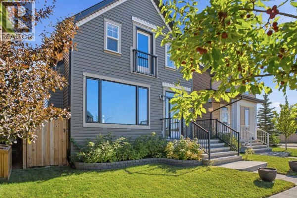 The front of a grey modern house with a large window and a front entrance with stairs. - 2534 Ravenswood View Se, Airdrie