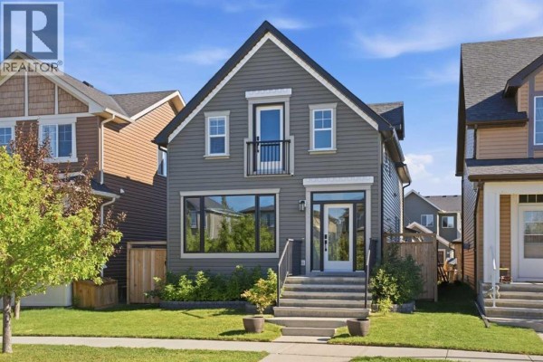 A modern two-story grey house with a peaked roof and a small balcony above the front entrance. - 2534 Ravenswood View Se, Airdrie