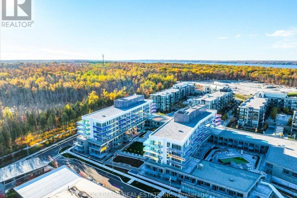 Exterior view of contemporary waterfront apartment buildings with balconies and green spaces. - 254 - 333 Sunseeker Avenue, Innisfil