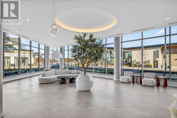 Bright and open lobby area featuring a large tree, contemporary seating, and floor-to-ceiling windows. - 254 - 333 Sunseeker Avenue, Innisfil