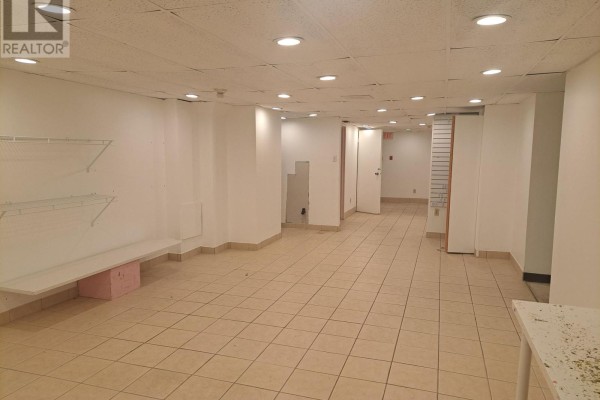 Empty commercial space with tiled floors, white walls, shelves, and multiple doorways leading to other rooms. - 254 Dalhousie Street, Ottawa