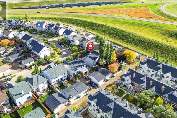 Aerial view of a residential street with duplexes, showing nearby highway and green space. - 254 Elgin View Se, Calgary