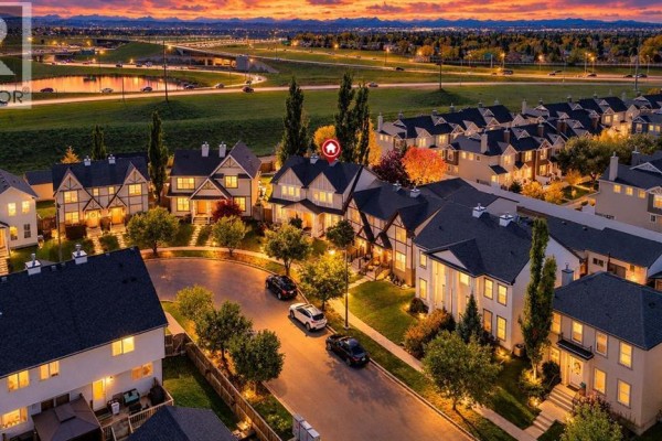 Aerial twilight view of a street with duplex homes, paved roads, and landscaping. - 254 Elgin View Se, Calgary