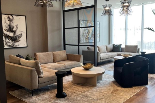 Lobby seating area with beige sectional sofas, a round coffee table, and modern chairs. - 925 - 2545 Simcoe Street N, Oshawa