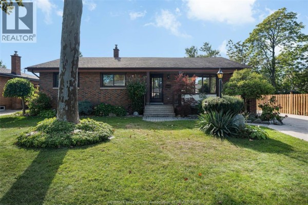 Front view of a single-story brick house with a covered porch and landscaped front yard. - 2545 St. Patricks's Avenue, Windsor