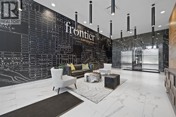 Apartment building lobby with a large map mural, seating area, and elevators. - 255, 110 18a Street Nw, Calgary