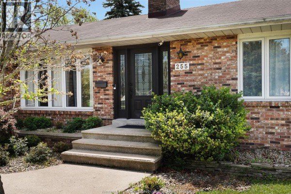 Home office with desk, computer, chair, bookshelves, and bay window overlooking a pool. - 255 Fort Street, Amherstburg
