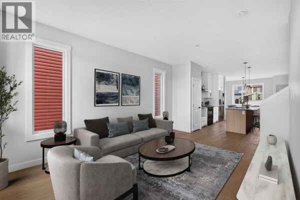 Living room with grey sofa, two chairs, a rug, coffee table, and kitchen island visible. - 255 Lucas Gate Nw, Calgary