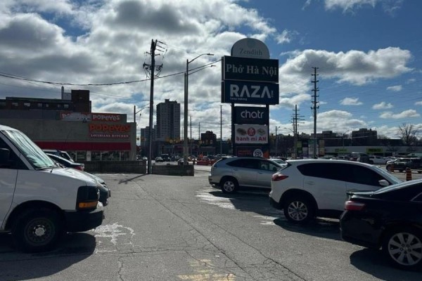 Parking lot view with signage for Zendith and nearby businesses. - 2551 Hurontario Street, Mississauga