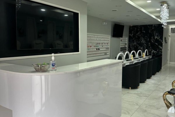 Modern spa interior with a service counter, nail stations, and decorative lighting. - 2551 Hurontario Street, Mississauga
