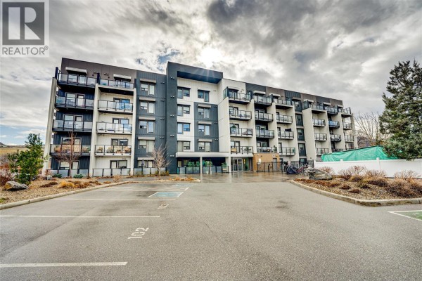 Front entrance of the building with parking area and balconies visible - 2555 Lakeshore Road Unit# 321, Vernon