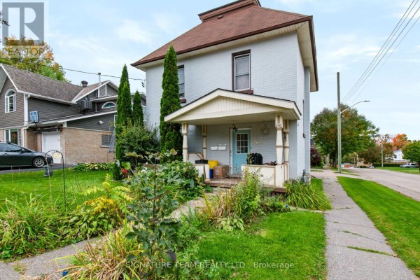 Exterior of a two-story white brick house showing the front entrance and porch. - 256 Maple Avenue, Pembroke