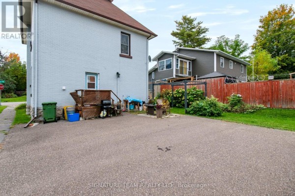 Backyard area with a gravel surface, deck, and storage shed next to the house. - 256 Maple Avenue, Pembroke