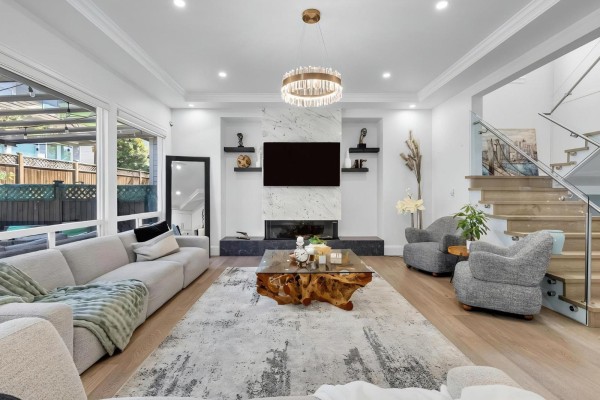 Spacious living room with a sectional sofa, fireplace, seating area, and view of the staircase. - 2560 163 Street, Surrey