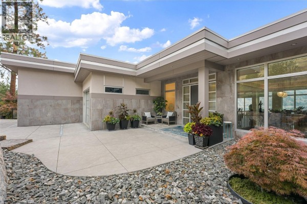 Front entrance of a modern home with stone accents and potted plants. - 2560 Arthur Road, Kelowna
