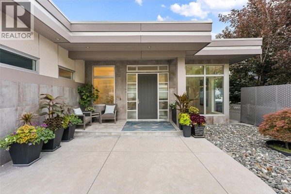 Close-up of the front entrance of a modern home with a gray door. - 2560 Arthur Road, Kelowna