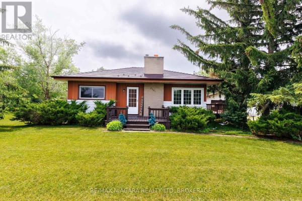 Front view of a single-story house with wood siding and a brick chimney. - 2561 Point Abino Road N, Fort Erie